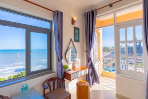 a room with a desk and a view of the ocean at Truong An Hotel in Vung Tau