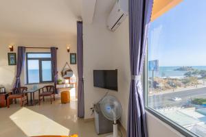 a living room with a window with a view of the ocean at Truong An Hotel in Vung Tau