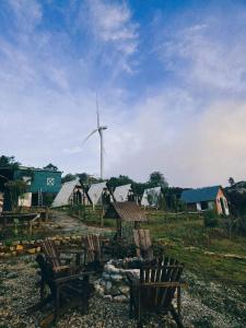 a windmill and a group of chairs in a field at An House in Xuân Trường +1 photo