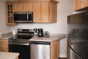 a kitchen with wooden cabinets and a stove top oven at Relaxing Poolside Condo in Savannah