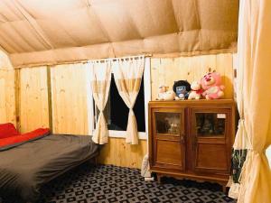 a room with a bed and a cabinet with stuffed animals at An House in Xuân Trường