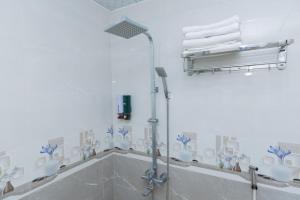 a bathroom with a shower with blue and white tiles at Truong An Hotel in Vung Tau +51 photos