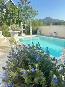 a swimming pool with blue flowers in front of it at Paiyawadee House khaoyai in Ban Hua Phrong