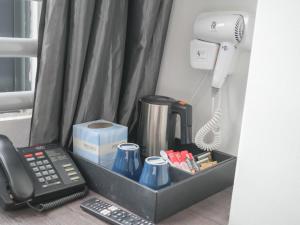 a desk with a phone and a coffee maker at A Hotel Dickson, Stay From 9PM To 8AM in Singapore