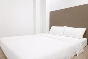a white bed with white sheets and pillows at A Hotel Dickson, Stay From 9PM To 8AM in Singapore +8 photos