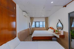 a hotel room with two beds and a mirror at Truong An Hotel in Vung Tau
