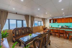 a living room with a table and chairs and a kitchen at Truong An Hotel in Vung Tau