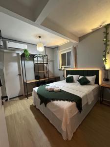 a bedroom with a large bed with a green blanket at Vibe Amazon in Manaus