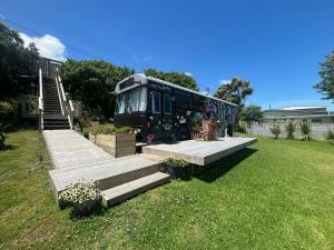 a bus parked in a yard next to some stairs at Luxury Beach Bus in Whanganui