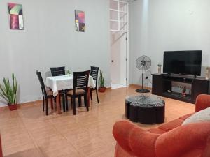 a living room with a table and chairs and a television at Departamento ANSOPH in Ilo