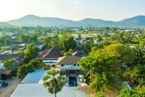 an aerial view of a town with houses and trees at Tongtong Garden Holiday Hotel普吉岛通通花园酒店 in Rawai Beach