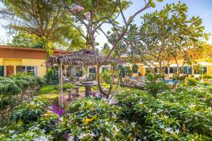 a garden with a table and a pavilion at Tongtong Garden Holiday Hotel普吉岛通通花园酒店 in Rawai Beach