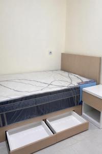 a bed in a room with two drawers at Diponegoro House Solo Baru in Solo