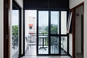 a glass door leading to a balcony with a table and chairs at Diponegoro House Solo Baru in Solo