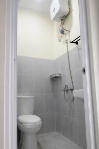 a bathroom with a toilet and a shower at Diponegoro House Solo Baru in Solo