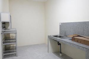 a kitchen with a sink and a refrigerator at Diponegoro House Solo Baru in Solo