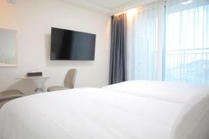 a bedroom with a bed and a window with a tv at 서프리조트 양양 빅웨이브 in Yangyang