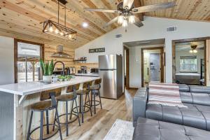 a kitchen and living room with a bar and a couch at Fish Sam Rayburn! Secluded Cabin w/ Deck & Grill in Brookeland