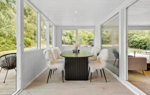 a dining room with white chairs and a table at Nice Home In Farsø With House A Panoramic View in Farsø