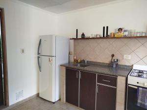 eine Küche mit einem weißen Kühlschrank und einer Spüle in der Unterkunft Tres sueños in Pueblo Esther