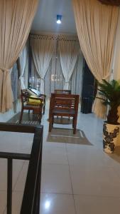 a living room with two chairs and curtains at Deva'sya Room Rent Nusa Dua in Nusa Dua