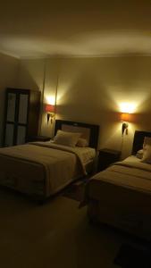 a hotel room with two beds and two lights at Deva'sya Room Rent Nusa Dua in Nusa Dua