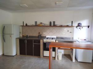 eine Küche mit Herd, Kühlschrank und Tisch in der Unterkunft Tres sueños in Pueblo Esther + 2 Fotos