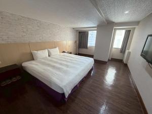 a bedroom with a large bed and a television at Long Siang Hotel in Kaohsiung
