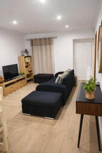 a living room with a couch and a tv at Alojamento dos cagarros in São Sebastião +28 photos