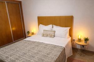 a bedroom with a large bed with two night stands at Alojamento dos cagarros in São Sebastião