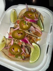 a white plate with two sandwiches with peppers and onions at Sohla Rooftop Hostel in San Juan del Sur