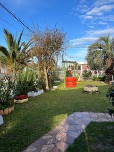 a garden with palm trees and a playground at Picaflor in Barra del Chuy +4 photos