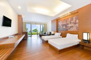 a hotel room with a bed and a tv at SYLVAN Koh Chang in Ko Chang