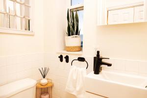 un bagno bianco con lavandino e vasca da bagno di Dundas and Brock Suitel a Toronto Altre 95 foto