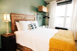 una camera da letto con un grande letto bianco con una finestra di Dundas and Brock Suitel a Toronto