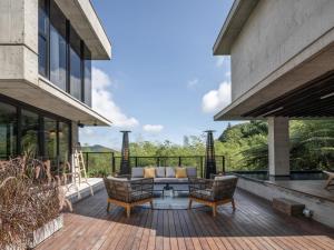 a patio with a couch and chairs on a deck at Deer Chaser Xitou in Lugu Lake