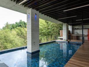 a swimming pool with a view of the trees at Deer Chaser Xitou in Lugu Lake