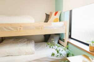 a bedroom with two bunk beds and a window at Near Ikebukuro, Kitchen & Laundry, Fast Wi-Fi, 4min to Station,Many restaurants nearby!! in Tokyo