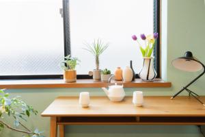 a table with vases and plants on a window sill at Near Ikebukuro, Kitchen & Laundry, Fast Wi-Fi, 4min to Station,Many restaurants nearby!! in Tokyo