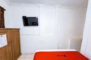 a room with a bed and a tv on a wall at RedDoorz at Lumungga Residence Lampung in Lampung +17 photos