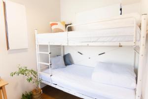 a white bunk bed in a white room with pillows at Near Ikebukuro, Kitchen & Laundry, Fast Wi-Fi, 4min to Station,Many restaurants nearby!! in Tokyo