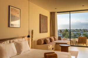 a hotel room with a bed and a couch at Sore Escape Tumbak Bayuh by Betterplace in Canggu