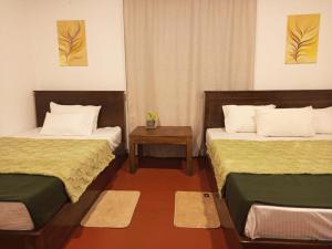 a room with two beds and a table at Riverston view hostel in Matale