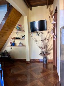 a hallway with a television on a wall with shelves at Apartamento in Barra del Chuy