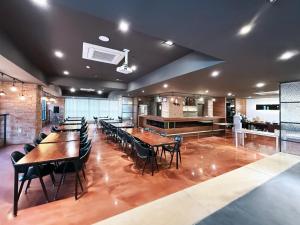 a restaurant with tables and chairs and a kitchen at Residence Hotel K Okpo in Geoje