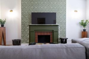 a living room with a fireplace with a flat screen tv at Spacious Haven near Busch ABODEbucks in Soulard