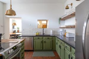 a kitchen with green cabinets and a sink at Spacious Haven near Busch ABODEbucks in Soulard