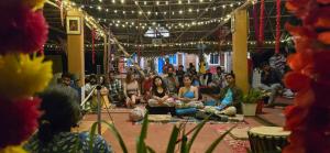 a group of people sitting on the floor in a room at WoodPacker Hostel Auroville Pondicherry in Auroville