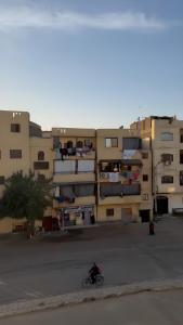 a person riding a bike in front of a building at Dahabiya Apartment in Luxor