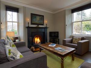 a living room with a couch and a fireplace at Dunvegan Castle Gardens Cottage in Dunvegan